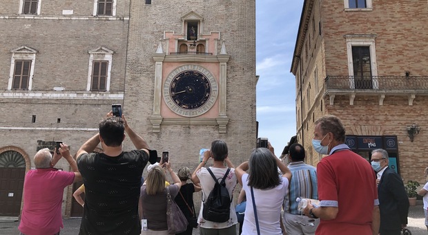 Turisti in piazza della Libertà sotto la Torre dell'orologio