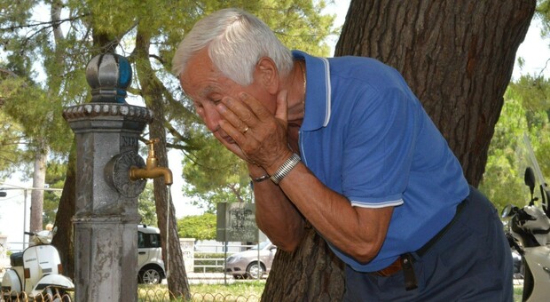 Un anziano mentre si rinfresca in una fontanella pubblica