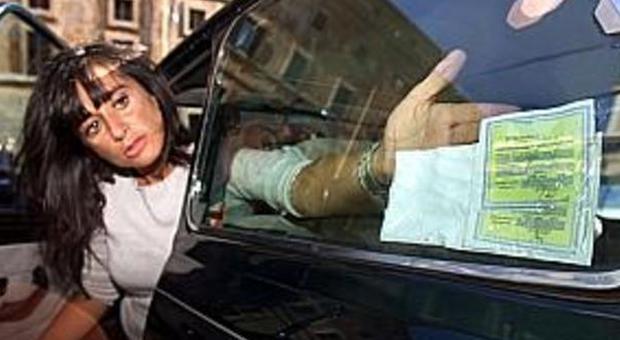 Una donna colloca il contrassegno dell'assicurazione sulla sua auto