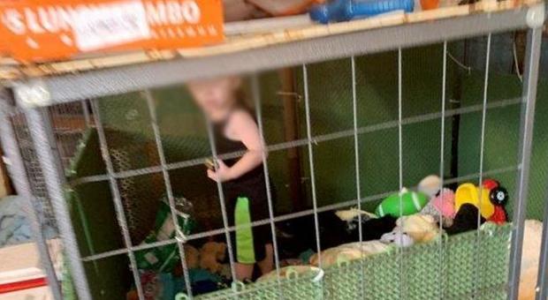 Bambino di un anno e mezzo tenuto chiuso in gabbia: intorno a lui animali, armi e droga