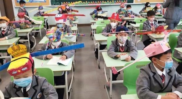Scuola riaperta, bambini in classe con metro in testa in Cina
