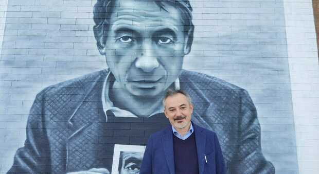 Lo scrittore e giornalista fermano Angelo Ferracuti davanti al murales di Mario Dondero
