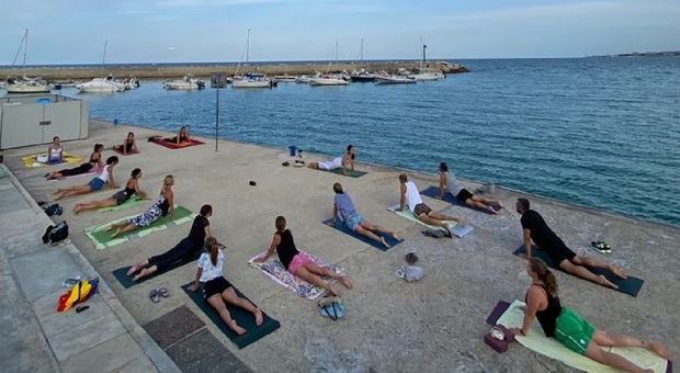 Una lezione di yoga in riva al mare