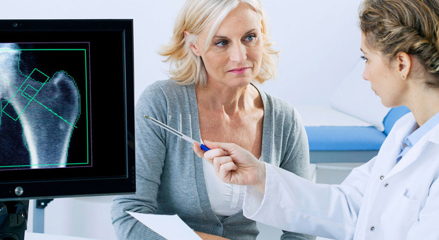 Un medico visita una donna affetta da osteoporosi