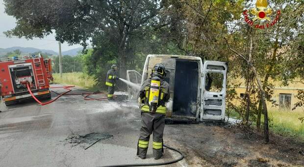 Il furgone distrutto dalle fiamme e l'intervento dei vigili del fuoco
